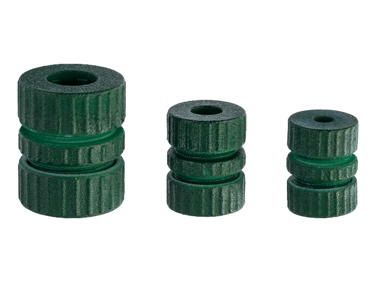 Drie stapels groene, cilindrische plastic onderdelen van verschillende hoogtes.