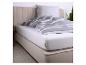 Bed met grijs gestreept dekbed en wit hoeslaken.