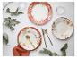 Servies met bloemmotief: borden, vorken, messen en lepels op een witte achtergrond.