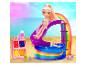 Een pop in badpak glijdt van een regenboogglijbaan in een zwembad met accessoires op een strand.
