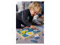 Een peuter speelt met een houten puzzel met ruimtethema.