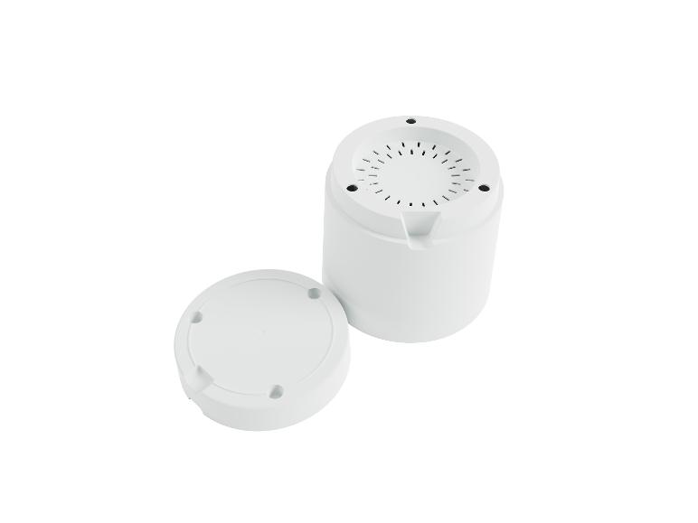 Twee witte behuizingen, een cilindrische en een ronde, voor elektronische apparatuur.