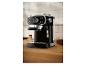 Zwart espressomachine op een houten aanrecht met koffiebonen en gemalen koffie