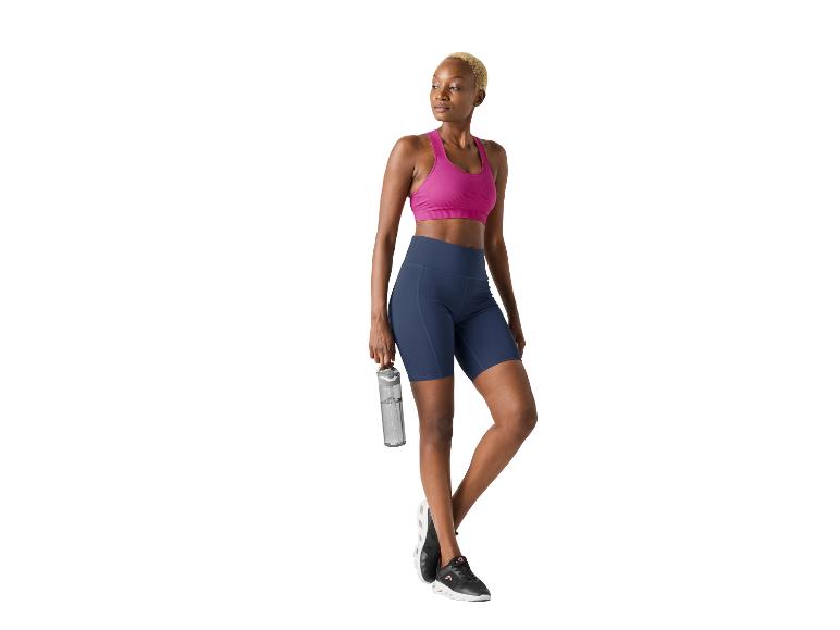 Vrouw in sportbeha en fietsbroekje met een waterfles.