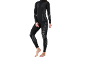 Vrouw in zwarte thermische top met lange mouwen en bijpassende legging met grijze patronen.