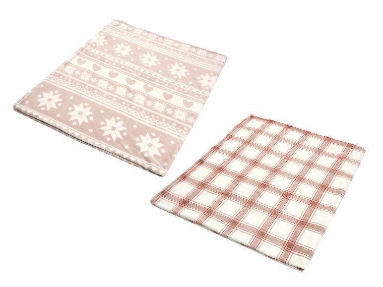 Twee zachte dekens, één met sneeuwvlok- en hartpatronen, de andere geruit.