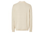 Een crèmekleurige gebreide trui met lange mouwen.