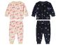 Twee sets kinderpyjama's: een met kerstboomprint, de andere met sneeuwvlokken.