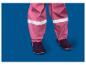 Roze kinderregenbroek met reflecterende strepen en donkere laarzen.