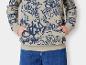 Een beige hoodie met blauwe graffitiprint en blauwe jeans.