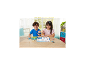 Twee lachende kinderen houden kleurrijke kralencreaties vast aan een houten tafel.