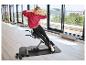 Vrouw traint op een buikspiertrainer met dumbbells in een lichte kamer.