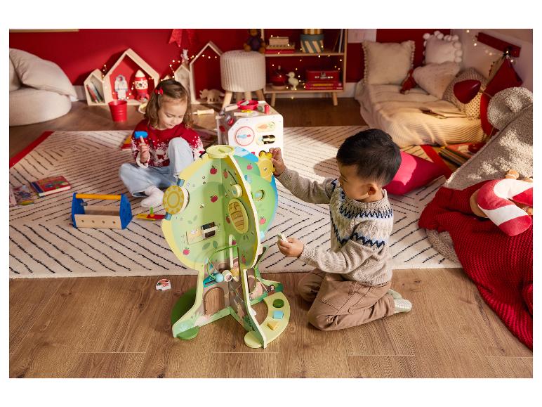 Twee kinderen spelen met een houten activiteitencentrum en een speelgoedgereedschapset in een gezellige kamer.