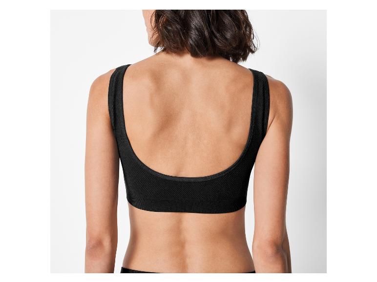 Een vrouw draagt een zwarte bh zonder beugel.