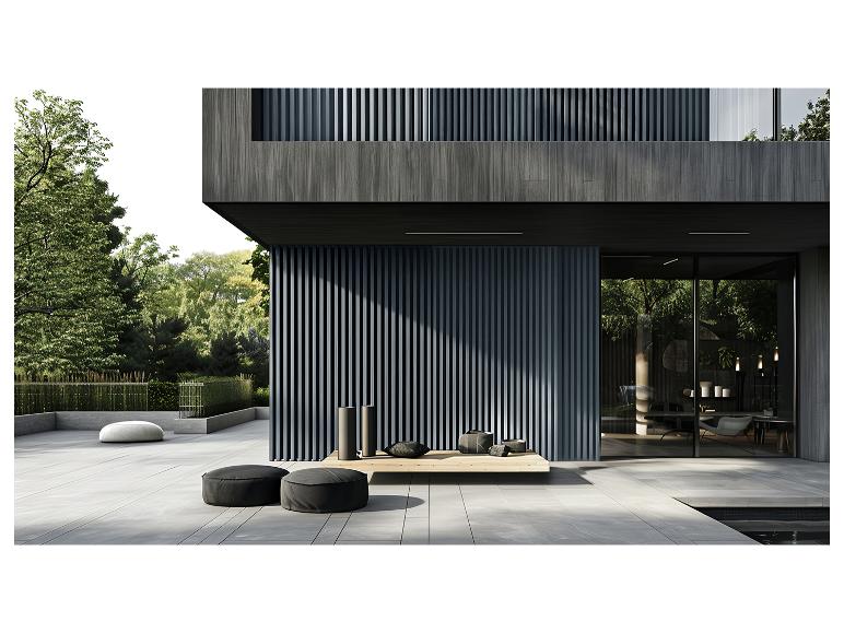 Moderne buitenpatio met zwarte poefs, groene tuin en houten gevel.