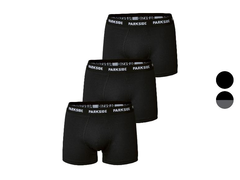 Verpakking van drie zwarte herenboxers met witte tailleband.