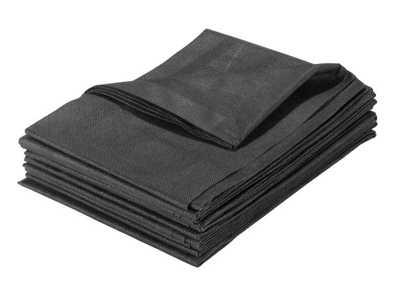 Stapel zwarte beschermhoezen voor meubels.