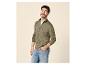 Man in groen gebreid vest met rits en blauwe jeans, glimlachend.