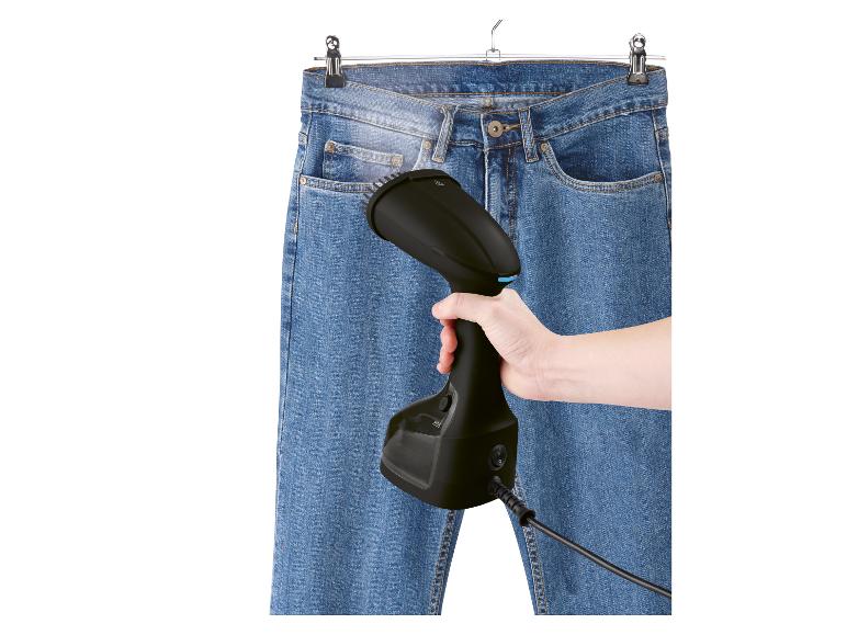 Een stoomstrijkijzer wordt gebruikt om een spijkerbroek te strijken.