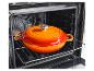 Oranje geëmailleerde gietijzeren braadpan in een open oven