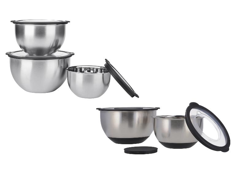 Roestvrijstalen mengkommen set met zwarte deksels, sommige gestapeld.
