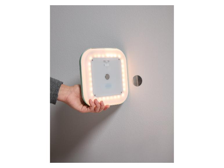 Iemand houdt een draadloze LED-wandlamp vast.