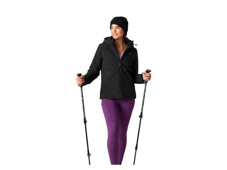 Vrouw in zwarte jas en paarse legging met wandelstokken.