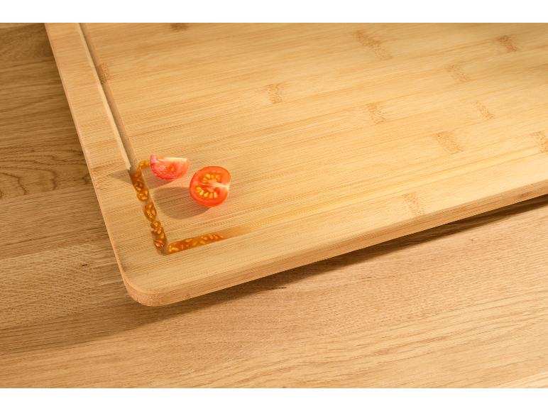 Houten snijplank met gesneden cherrytomaten en sap.