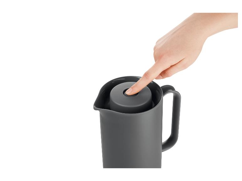 Een hand opent een thermoskan met vacuüm isolatie.