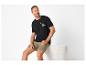 Zittende man in zwart 'ROAD TRIPPIN' T-shirt en kaki shorts.