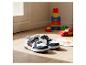 Kindersneakers met automotieven, speelgoed en tekeningen op een houten vloer.