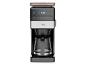 Koffiezetapparaat met digitaal display 8:30, glazen kan en oranje accenten.