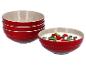Drie rode Le Creuset kommen gestapeld, naast een kom met yoghurt en fruit.