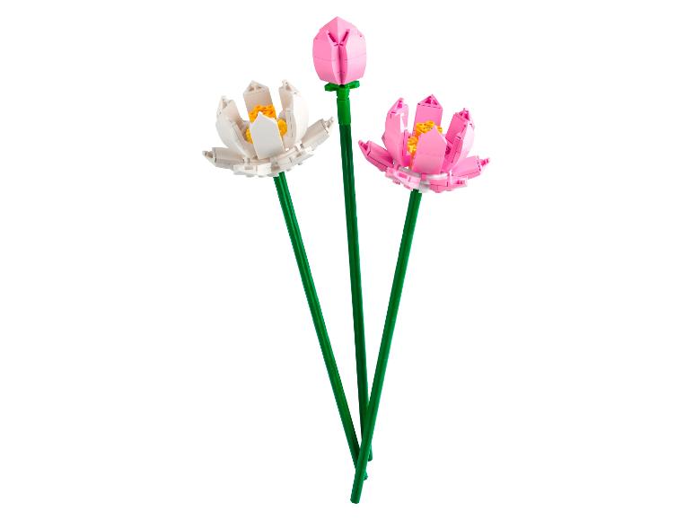 Drie LEGO bloemen met roze en witte bloemblaadjes.
