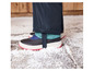 Zwarte snowboots met zwarte broek op een besneeuwde ondergrond.