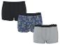 Drie katoenen boxershorts voor heren: een zwarte, een met ananas- en palmbomenprint, en een grijze.