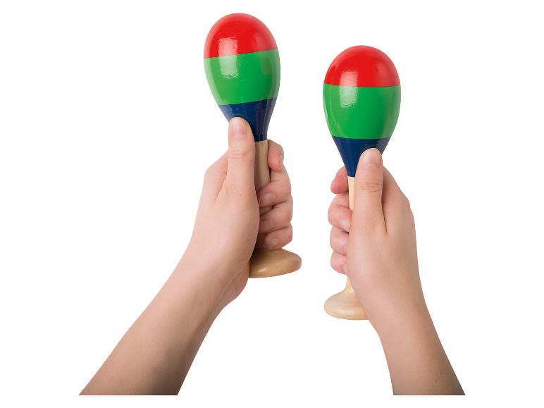 Twee handen houden kleurrijke maracas vast, rood, groen en blauw