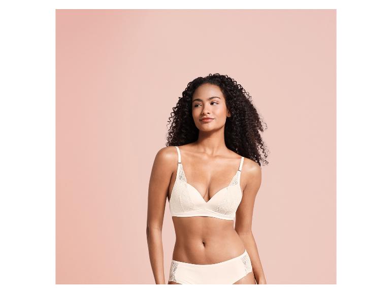Een vrouw draagt een witte beha en slip met kant.