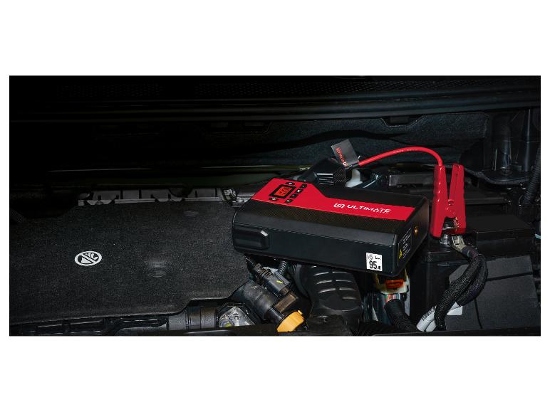 Rode en zwarte auto-startbooster in motorruimte met 100% laadscherm.