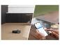 Robotstofzuiger reinigt houten vloer, bediend via een smartphone.