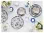 Tafeldekking met blauw-wit servies met vogel- en bloemmotieven, bloemen en kaarsen.