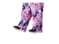 Kinder skibroek met kleurrijke bloemenprint en zwarte sneeuwschoenen.