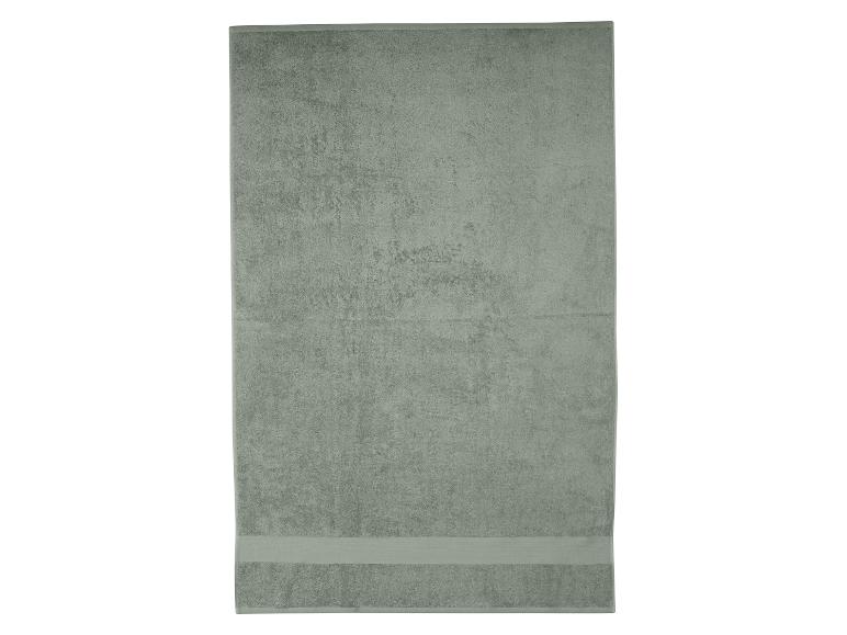 Lichtgroene badhanddoek met een decoratieve band aan de onderkant