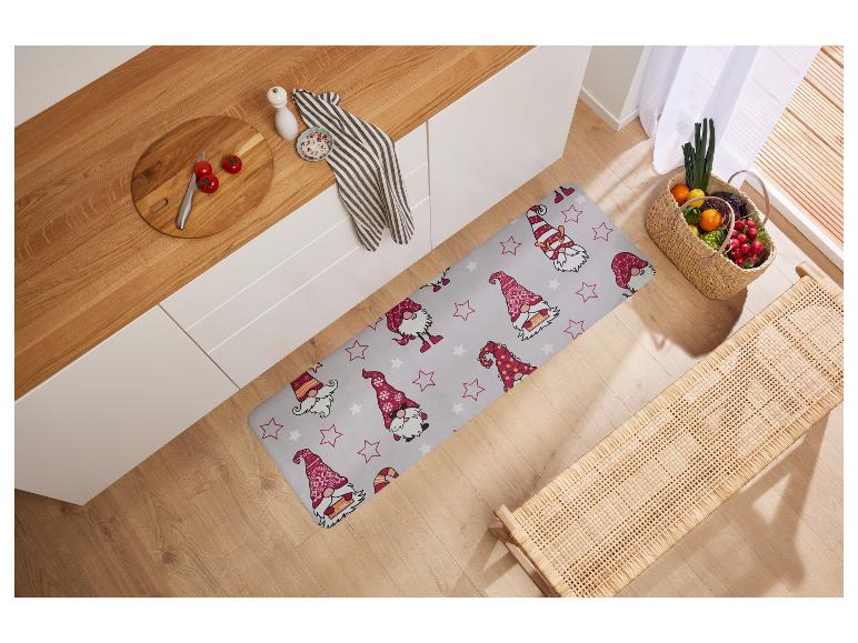 Keukenmat met kerstkabouters in een keuken met een houten aanrecht en groenten.