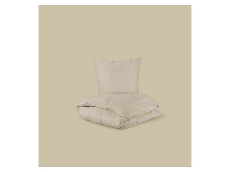 Beige dekbedovertrek en kussensloop set op een bijpassende achtergrond.