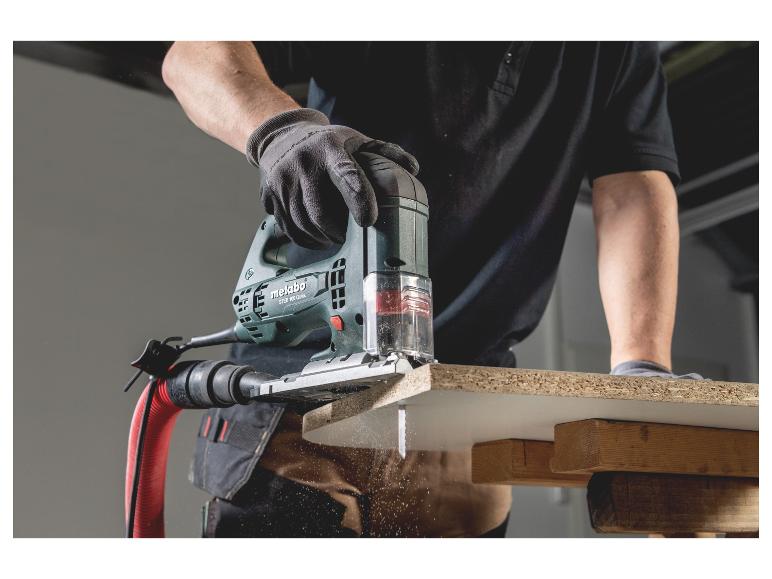 Metabo decoupeerzaag zaagt hout, zaagsel vliegt.