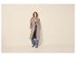 Vrouw in beige trenchcoat, gestreept overhemd, jeans en tweekleurige loafers.
