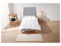Een wit dekbed op een grijs bedframe met een vloerkleed en een stoel.