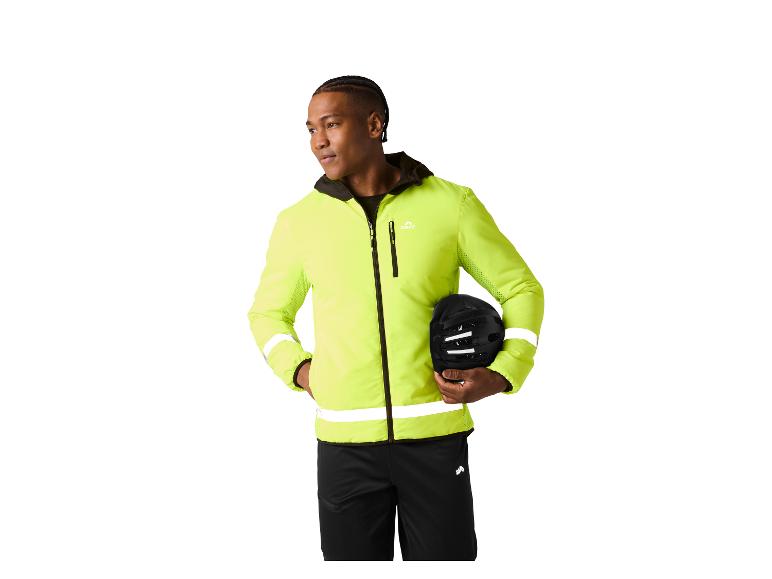 Man in neongele fietsjas en zwarte broek, met een fietshelm in de hand.