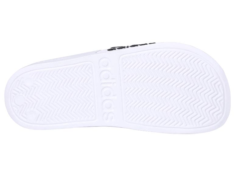 Zool van witte Adidas slippers.